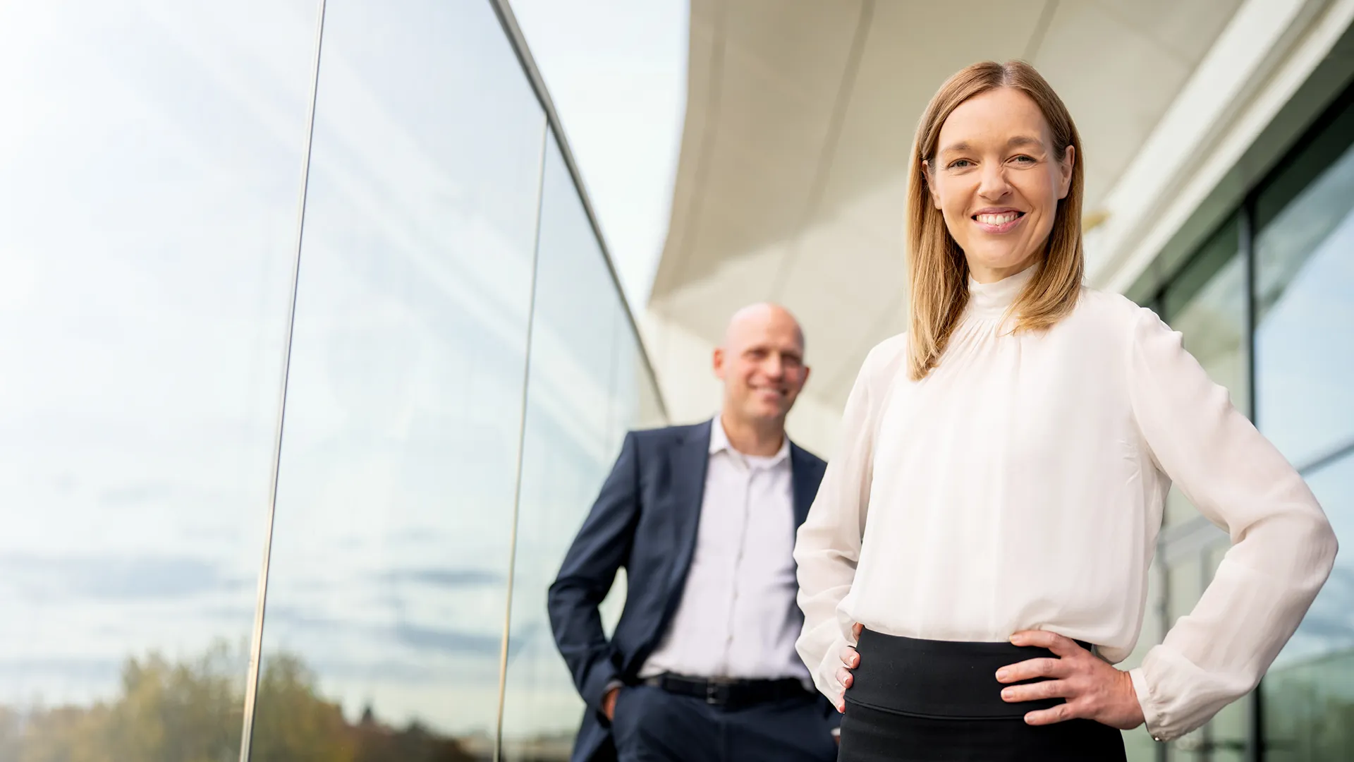Eine Frau und ein Mann stehen vor einer Glaswand